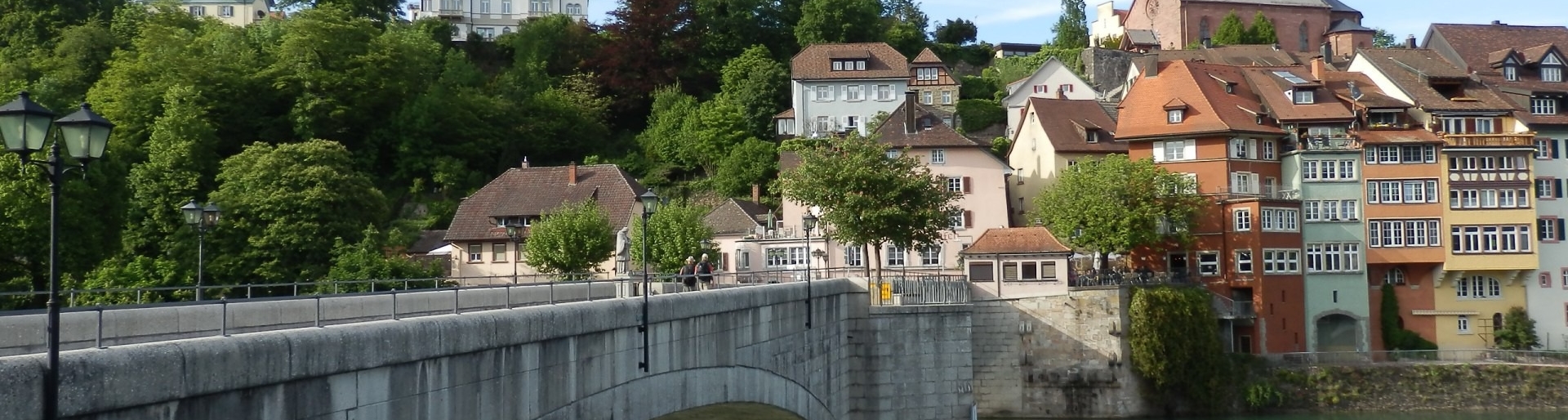 Sehenswürdigkeiten im Aargau - Steinbrücke vor bunten, historischen Häusern am Fluss