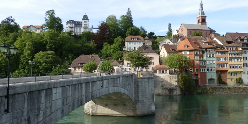 Sehenswürdigkeiten im Aargau - Steinbrücke vor bunten, historischen Häusern am Fluss
