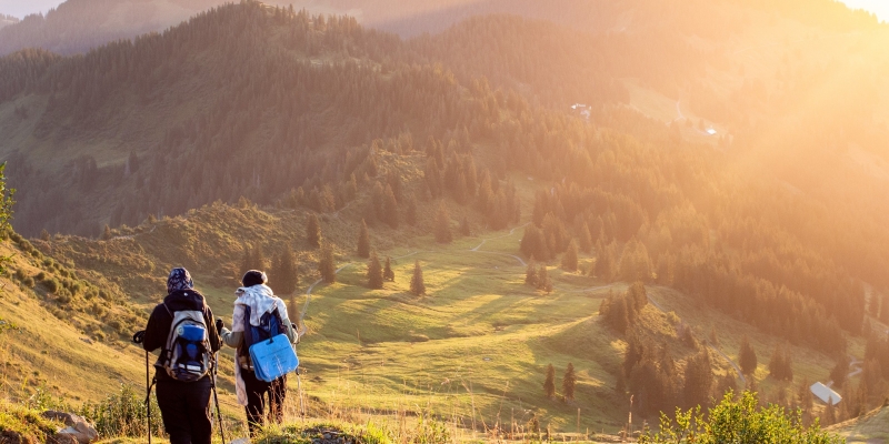 Ausflugsziele im Aargau - malerische Berglandschaft bei Sonnenuntergang mit zwei Wanderern auf einem schmalen Pfad