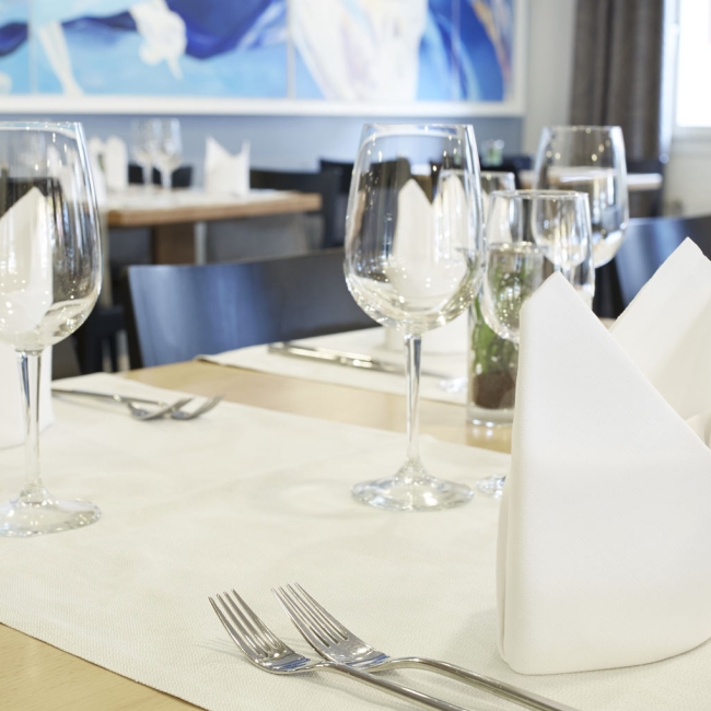 Stilvoll eingedeckter Tisch mit Servietten und Weingläsern 