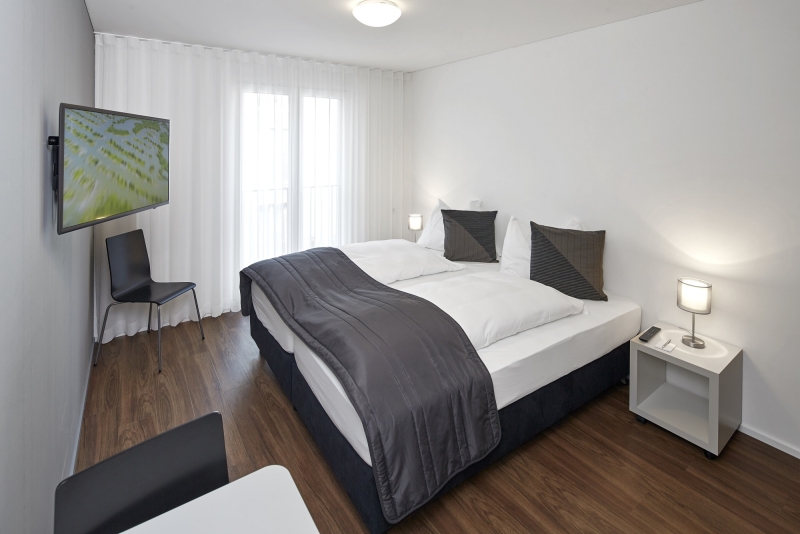 Boxspringbett in einem modernen Zimmer im Business Apartment bei Zürich 