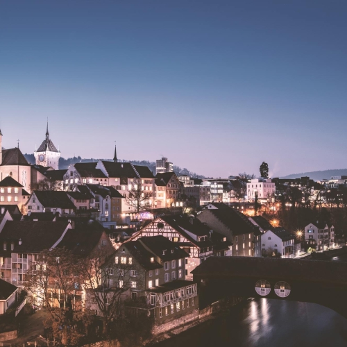 Apartment Hotel in Zürich mit Blick auf die beleuchtete Stadt am Abend 