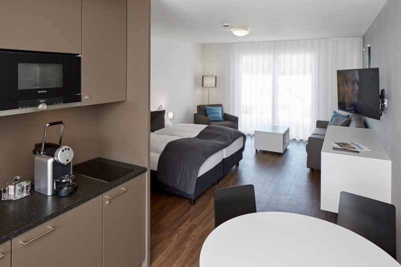 Helles Zimmer mit Terrasse und Küchenzeile im Serviced Apartment bei Zürich 