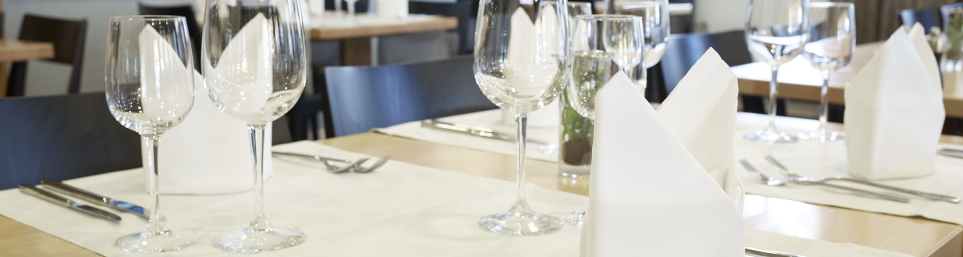 Stilvoll eingedeckter Tisch mit Servietten und Weingläsern 