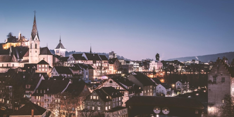 Apartment Hotel in Zürich mit Blick auf die beleuchtete Stadt am Abend 
